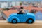 Blue car toy from side in wood rail with blured city in background