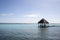 blue Caribbean sea with crystal clear waters and clear sky. a bungalow with a pier in the middle of the lagoon in a coral