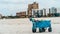 Blue cart on sandy beach ominous clouds
