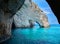 Blue caves rock arces arches of Blue caves from sightseeing boat with tourists in blue water of Ionian Sea inside cave, Island Zak