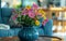 A blue ceramic vase holds a vivid arrangement of gerbera daisies, adding a burst of color to a modern living room.