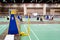 Blue chair of badminton referee with yellow colors near badminton net with blurred background in sport indoor stadium