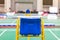 Blue chair of badminton referee with yellow colors near badminton net with blurred background in sport indoor stadium