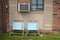 Blue Chairs Sitting Below an Apartment Air Conditioner