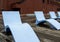 Blue Chaise Lounges on Wood Pier by Brick Building