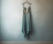 blue chiffon evening dress hanging up against pale blue wall