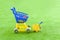 Blue children`s trolley on a green background with a yellow bucket and spatula