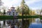 Blue Chinese gazebo among the trees, reflected in the water of the Catherine Park pond