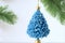 A blue Christmas tree is decorated with silver snowflakes and a gold star.The image is both festive and elegan, , and it is