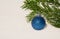 Blue Chritmas bauble and an evergreen twig on snow,