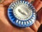 A blue circular daily pill dispenser for hormone replacement therapy HRT, in Spanish