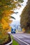 Blue classic modern semi truck on winding autumn road