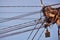 Blue clear sky and pole with large bundle of electric wires.