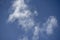 Blue clear sky with white feathery clouds.