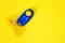 Blue clicker, special tool for dog training, on positive motivation and reinforcement. Bright yellow background. Pet train, animal