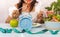 Blue clock for Intermittent fastin concept and woman eating salad background in the kitchen