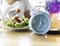 blue clock which woman make a Intermittent fasting with a Healthy food of salad .Healthy lifestyle Concept
