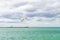 Blue clouded sky, clear sea water, panoramic skyline, sea-gulls, coast view from a sea.