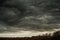 Blue clouds slowly float across the sky, over the newly plowed field, early spring morning