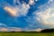 Blue cloudscape over green meadows in the countryside