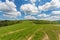 Blue cloudy sky over green hills and country road