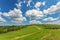 Blue cloudy sky over green hills and country road