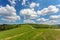 Blue cloudy sky over green hills and country road