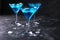 Blue cold cocktails drink with ice cubes on a dark background