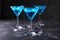 Blue cold cocktails drink with ice cubes on a dark background