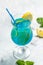 Blue cold drink and ice cubes, with fresh green mint leaves on deep blue and light blue background. Alcoholic or non-alcoholic