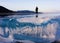 Blue and cold ice of Lake Baikal. Silhouette of a man