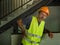 Blue collar job lifestyle. Portrait of tired and exhausted construction worker in helmet and vest at building site complaining of