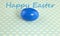 Blue-colored boiled egg on a blue background for Easter, top view, close-up, card with the inscription happy Easter