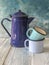 Blue colored enamel teapot and mugs on a wooden table