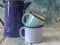 Blue colored enamel teapot and mugs on a wooden table