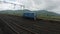 A blue colored railway locomotive running on tracks in Konkan