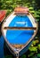 Blue colored wooden rowboat at the pier of a lake for rent surrounded by nenuphar. Municipal city park. Hamburg