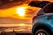 Blue compact SUV car with sport and modern design parked on concrete road by the sea at sunset. Road trip travel on vacation at