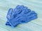 Blue construction gloves on wooden plank background close-up