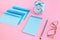Blue correspondence envelopes, clock and notebook on pink background with copy space. Back to school or work concept