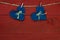 Blue country hearts hanging from clothesline by antique red wooden background