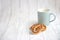 A blue cup and delicious bagels on a light wooden background. Background with place