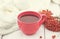 Blue cup of a therapeutic herbal tea with rowan berry on white rustic wooden table. Alternative medicine. Autumn Still Life.