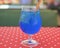 Blue curacao cocktail drink in glass with ice and lemon outside. Cold refreshing summer beverage