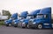 Blue day cab big rig semi truck for local delivery stand in row