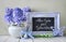 Blue decorations and hyacinth flowers on white table, blackboard