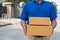 Blue Delivery man holding parcel cardboard box