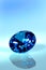 Blue diamond or sapphire in front of blue background, brilliant cut