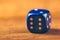 Blue dice on wooden table