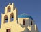 Blue dome greek orthodox church and belltower in Oia on Santorin